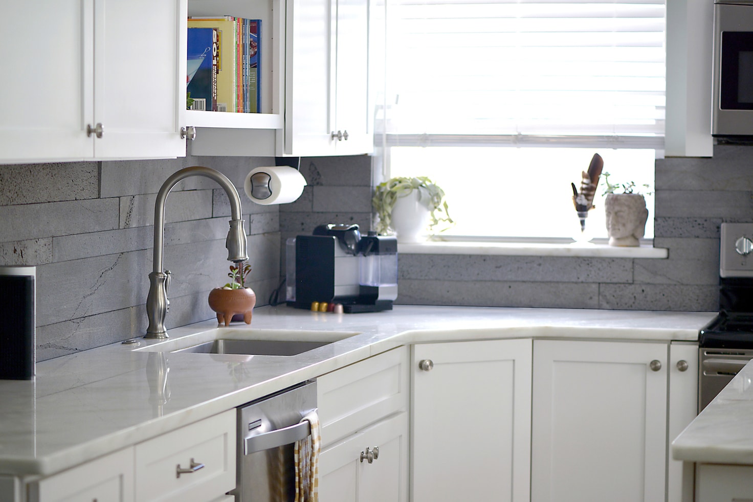 Planc Platinum used on a backsplash of a small modern kitchen with cabinets and white marble counter tops